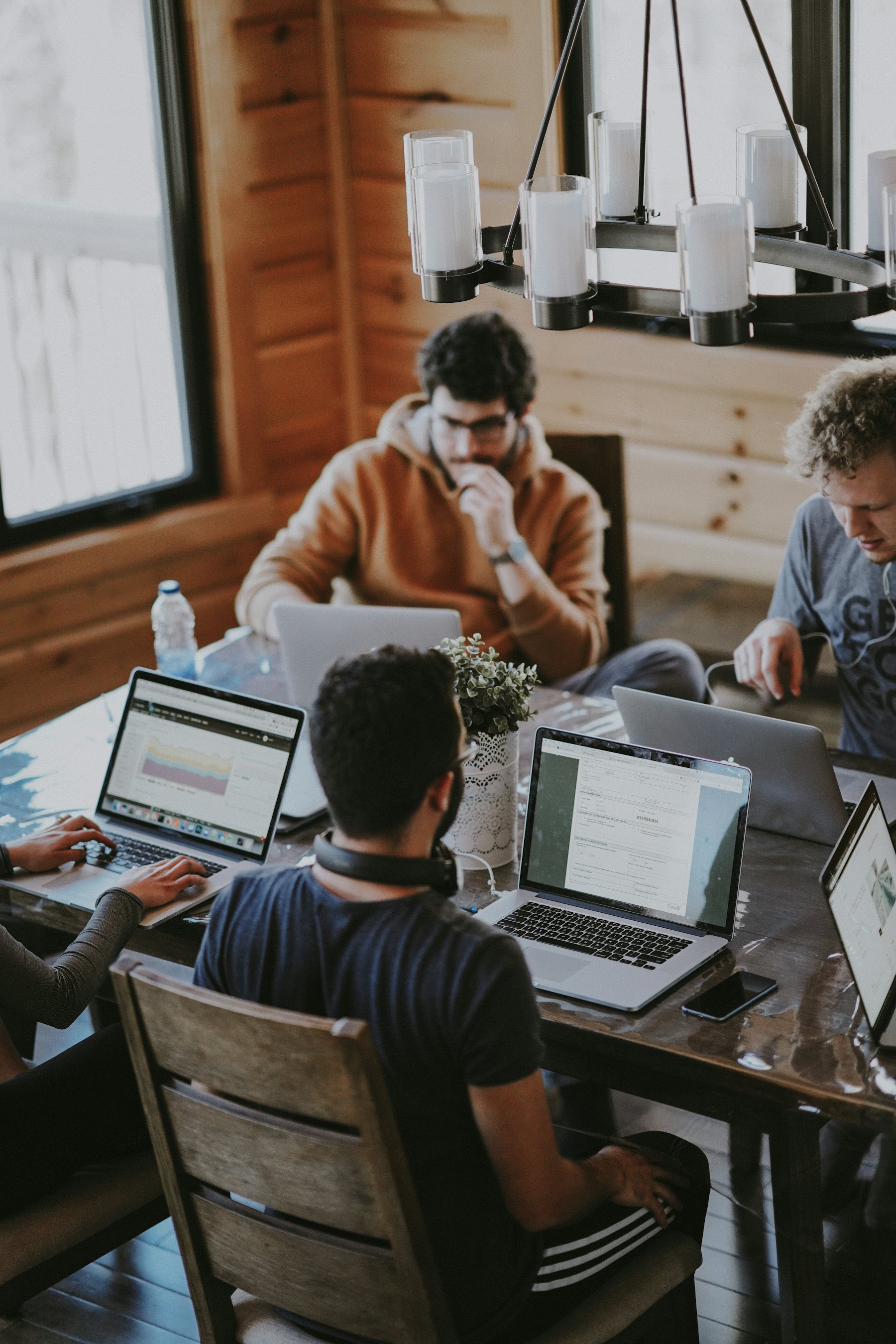 A small group working together around a table, laptops open